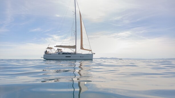 Un velero en aguas tranquilas bajo un cielo despejado.