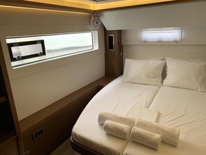 A bedroom with a bed, a window, and a small control panel. - Sun-Kissed Sailing Adventure in Islas Sarónicas (Alimos)