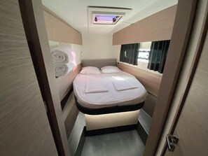 A compact bedroom with a bed, a window with curtains, a ceiling light, and a door. - Sun-Kissed Sailing Adventure in Zadar, Croatia (Bibinje)