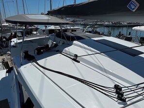 Eine Segelyacht mit einer geschlossenen Deckfläche, eine Website-URL und ein Logo.