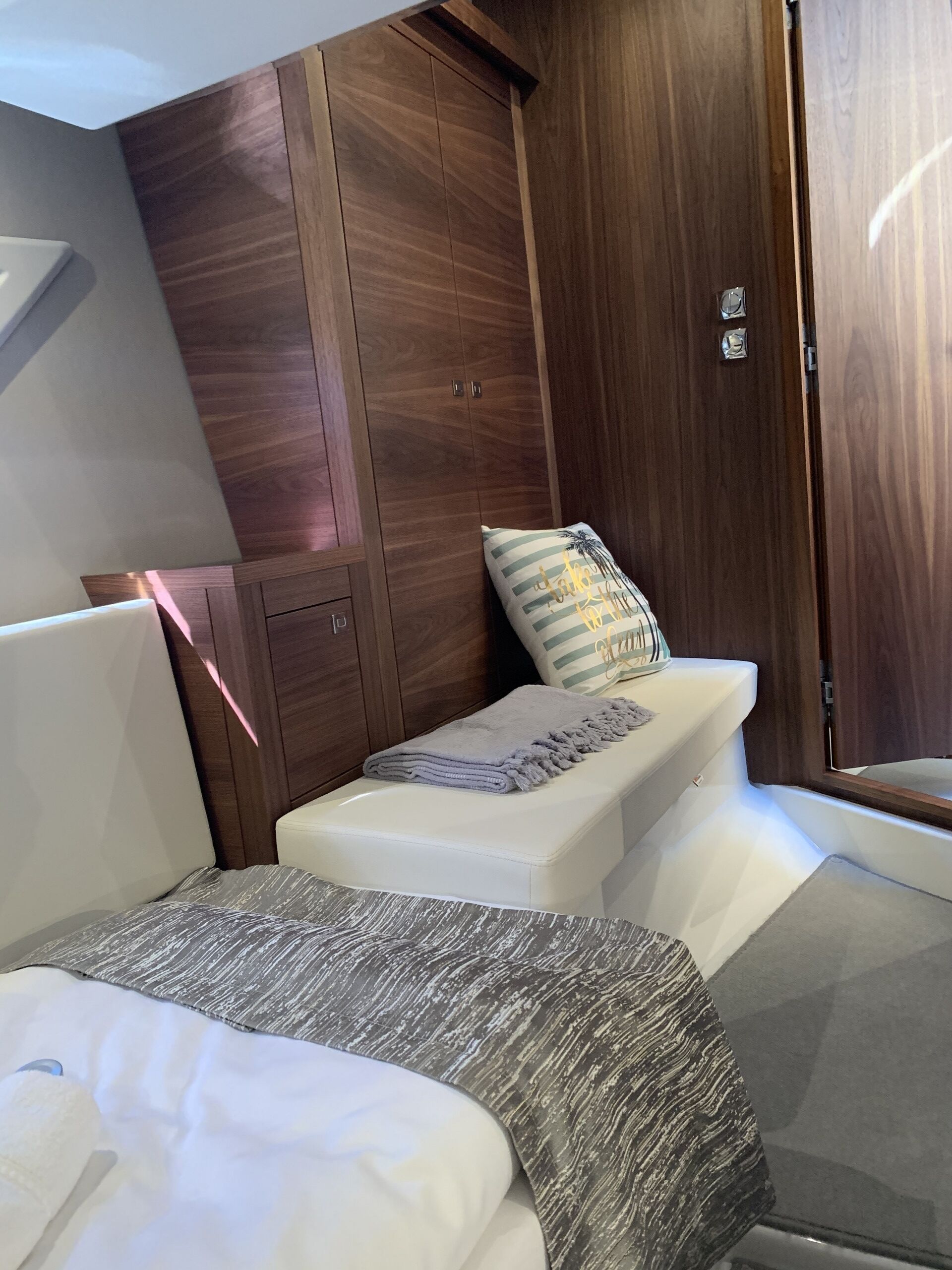 A bedroom with a bed, a bench, and a wardrobe.