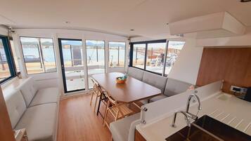 Une cuisine compacte avec un évier, un coin repas comprenant une table et des chaises, et un espace détente avec un canapé.