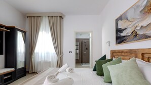 A hotel room with a bed, a wooden headboard, a painting, and a view of a bathroom.