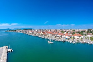 Eine Küstenstadt mit einem Hafen, Gebäuden am Wasser und einem strahlend blauen Himmel.