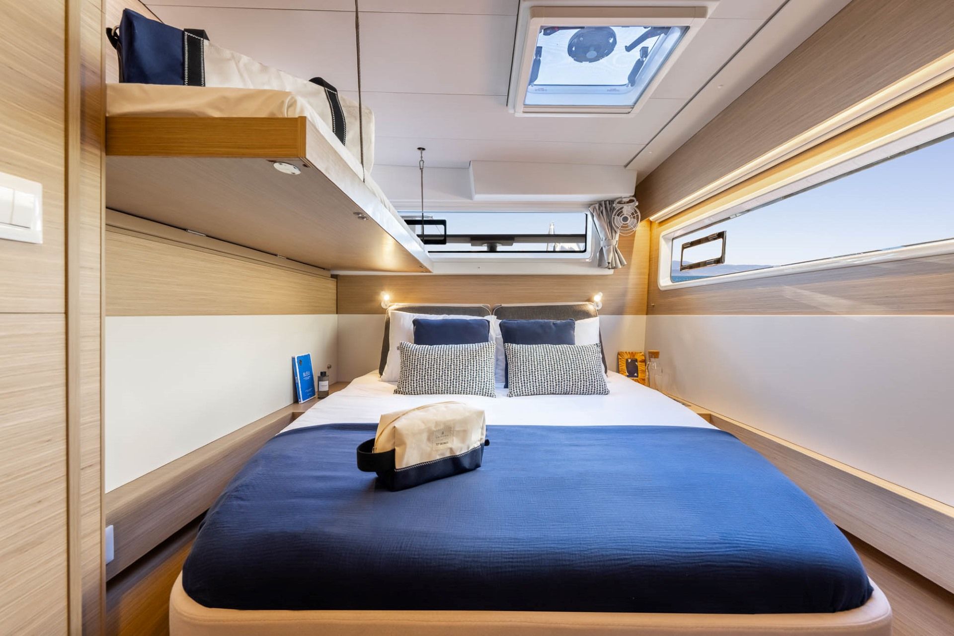 A compact, well-lit cabin with a bunk bed, a small table, and a skylight.