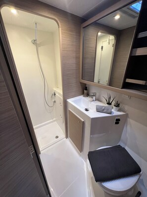 A compact bathroom with a shower, sink, and toilet. - Sun-Kissed Sailing Adventure in the Ionian Islands, Lefkada (Lefkada)