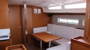 Een compact interieur met kitchenette, eettafel, zithoek en een raam voor natuurlijk licht.