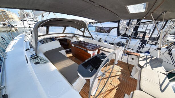 A boat deck with a wooden floor, a central seating area, and a view of other boats in the marina. - Sun-Kissed Sailing Adventure in Zadar, Croatia (Zadar)