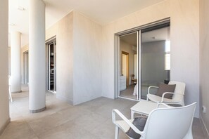 A modern interior with a glass door leading to a room, white chairs, and a tiled floor. - Zefiro Suite by BarbarHouse (Gallipoli)