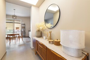 A modern kitchen with a dining area, a large mirror, and a central island with a lamp. - Zefiro Suite by BarbarHouse (Gallipoli)