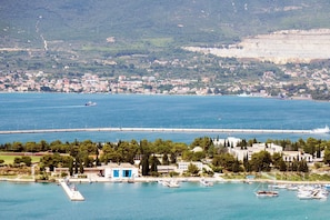 A coastal town with a marina, buildings, and a bridge. - Sun-Kissed Sailing Adventure in Split, Croatia (Kaštel Gomilica)