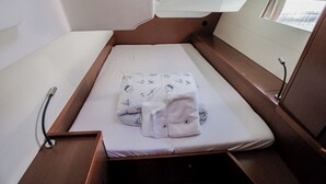 A compact cabin with a single bed, a small table, and a window. - Sun-Kissed Sailing Adventure in Split, Croatia (Kaštel Gomilica)