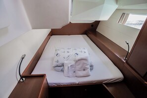 A compact cabin with a single bed, a small table, and a window. - Sun-Kissed Sailing Adventure in Split, Croatia (Kaštel Gomilica)