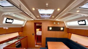 Un intérieur compact et bien éclairé, comprenant un coin repas, des sièges et une petite kitchenette.