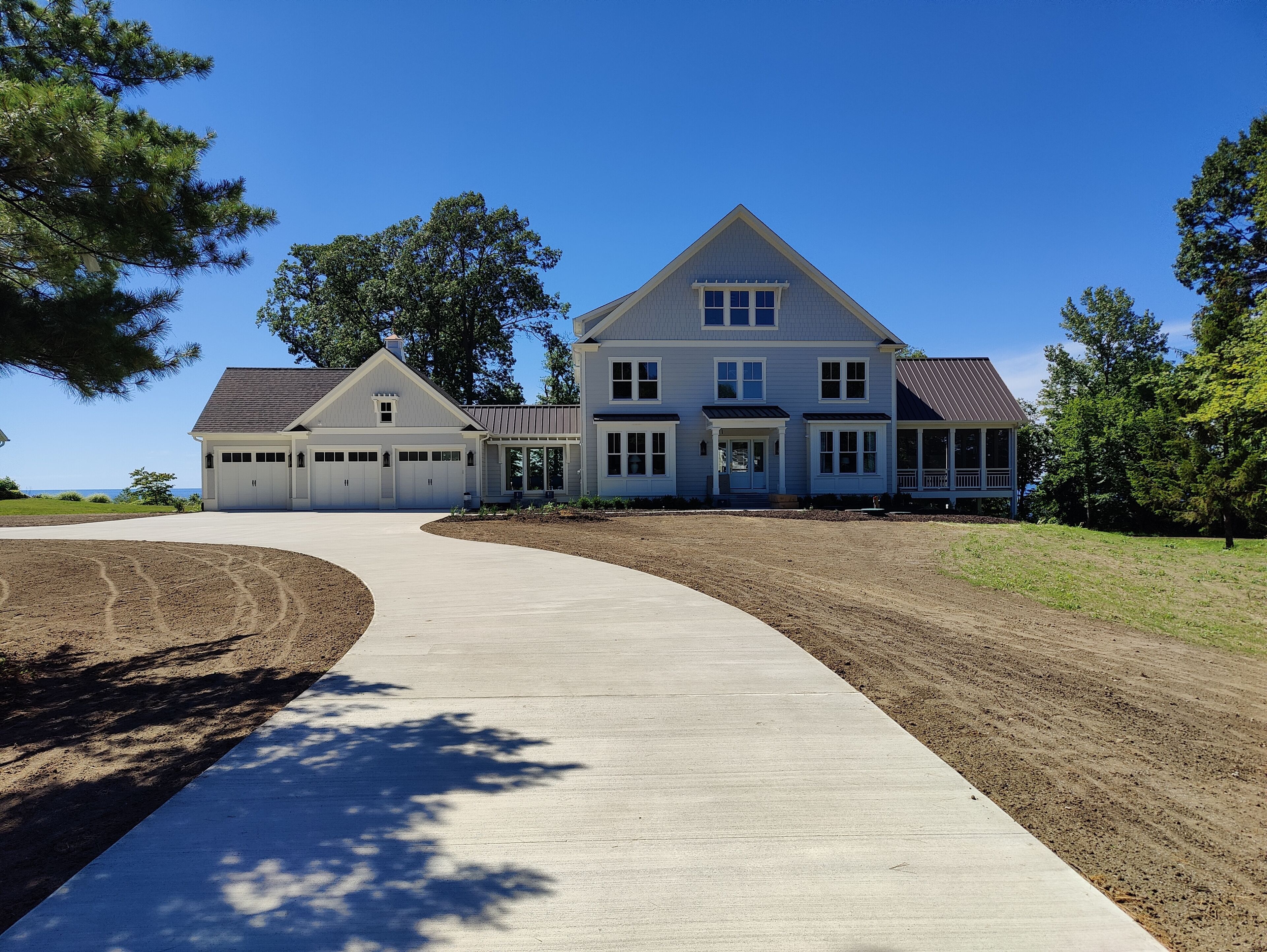 A large two-story house with a garage, a covered porch, and a driveway leading to the entrance.
