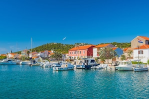 A coastal town with boats docked along the waterfront, buildings with red roofs, and a clear blue sky. - Sibenik Sun and Beach Sailing Extravaganza: A Croatian Coastal Adventure (Jezera)