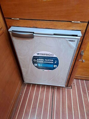A compact refrigerator with a sticker highlighting its energy efficiency and durability.