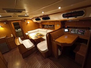 A compact interior with a dining area, seating, and a control panel.