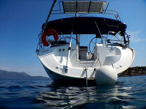 Un bote con casco blanco, un flotador salvavidas y un panel solar en la cubierta.