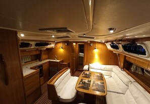 A compact interior with a dining area, a small kitchenette, and a sleeping berth.