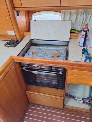 A compact kitchenette with a stove, a small oven, and a sink.