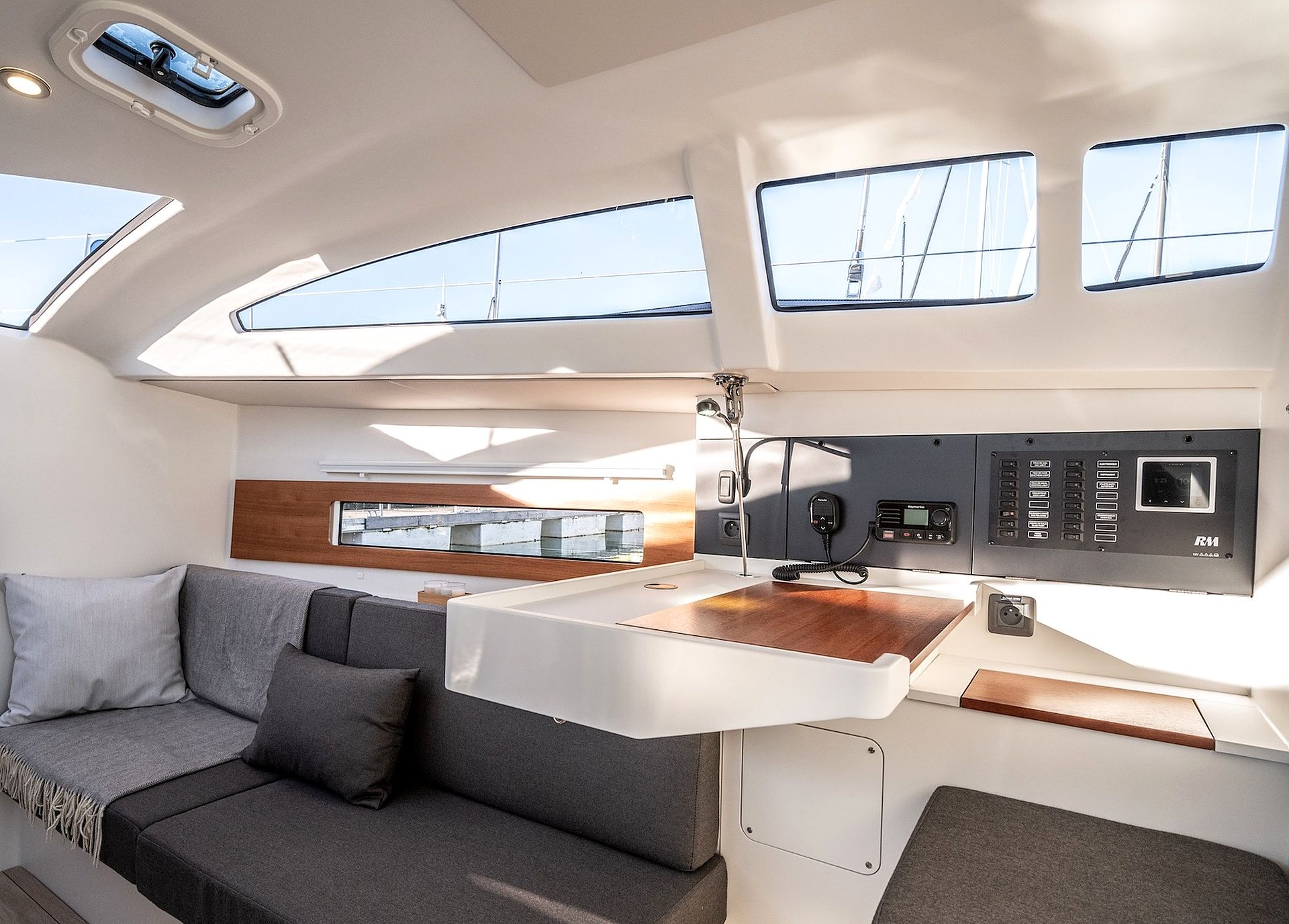 Un intérieur moderne avec un canapé, un panneau de commande et une vue sur l’extérieur.