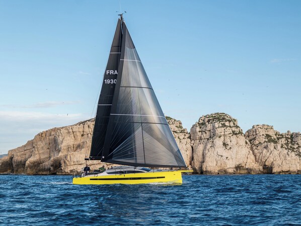 Un voilier à voile noire portant l’inscription « FRA 1930 » sur la coque.