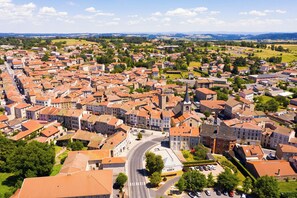 Vista aérea de un pueblo con una glorieta central, edificios históricos y zonas verdes circundantes.