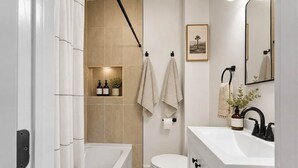 A modern bathroom with a bathtub, toilet, and sink. - Short Walk to Track & Broadway, SPAC Close Too! (Saratoga Springs)