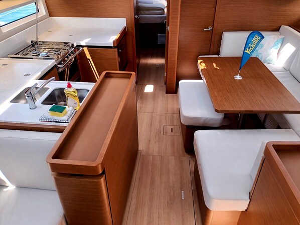 A compact kitchenette with a sink, stove, and storage cabinets.