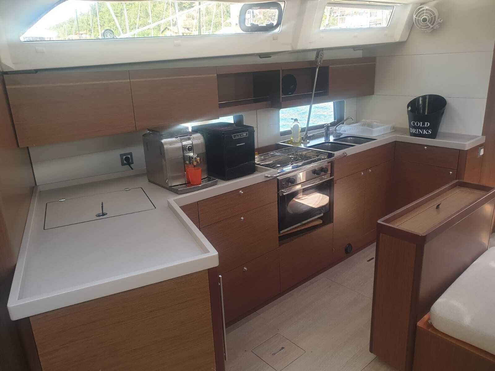 A compact galley kitchen with a coffee maker, oven, and sink.