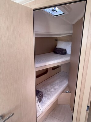 A compact bunk bed room with a skylight, a small storage compartment, and a door handle. - Sun-Kissed Sailing Adventure in Islas Sarónicas (Alimos)