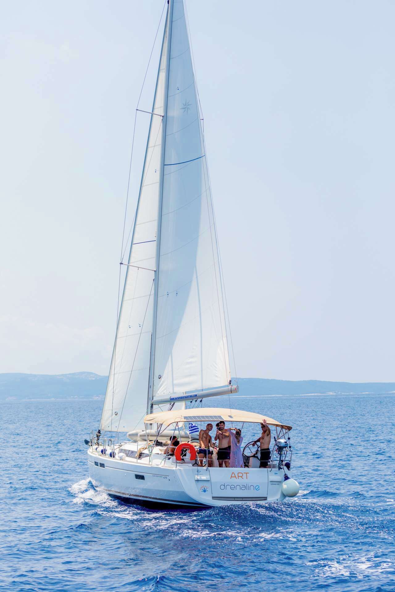 A sailboat with the name 'ART' and 'drenaline' on the side, sailing on the water.