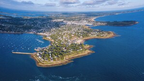An aerial view of a coastal town with a marina, residential areas, and a lighthouse. - Sun-Kissed Sailing Adventure in Golfo de Morbihan, Brittany (Arzon)