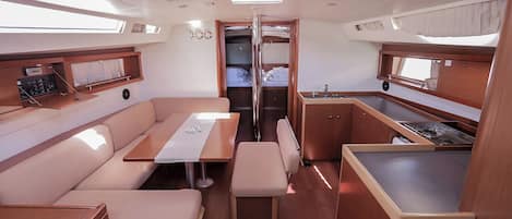 A compact interior with a dining area, kitchenette, and a small bathroom.