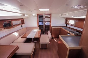 A compact interior with a dining area, kitchenette, and a small bathroom. - Sun-Kissed Sailing Adventure in Split, Croatia (Kaštel Gomilica)