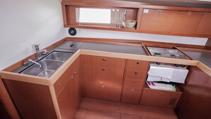 Una cucina compatta con lavello, fornelli e pensili.