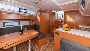 Una cocina pequeña y funcional con mesa de comedor, zona de estar, kitchenette y ventana.