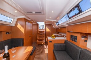 A compact, well-lit interior with a dining area, seating, a small kitchen, and a control panel. - Sun-Kissed Sailing Adventure in Zadar, Croatia (Zadar)