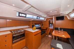 A compact galley with a stove, a small refrigerator, and a control panel. - Sun-Kissed Sailing Adventure in Zadar, Croatia (Zadar)