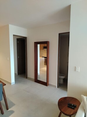 Corredor que dá para um banheiro e uma cozinha.