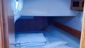 A compact interior with a bunk bed, a small window, and a wooden door. - Sun-kissed Sailing Adventure in Split-Dalmatia, Croatia (Trogir)