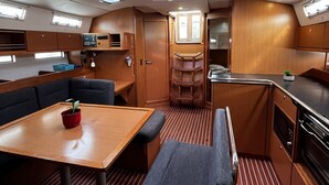 Um espaço interior pequeno e bem iluminado, com área de jantar, assentos e cozinha compacta.