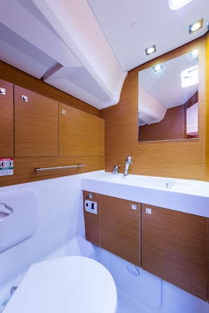 Un bany modern amb un envàs de fusta, un lavabo blanc i un mirall.