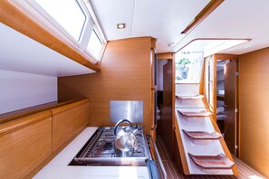 A compact kitchen with a stove, kettle, and a sink. - Sun-Kissed Sailing Adventure in the Ionian Islands, Lefkada (Lefkada)