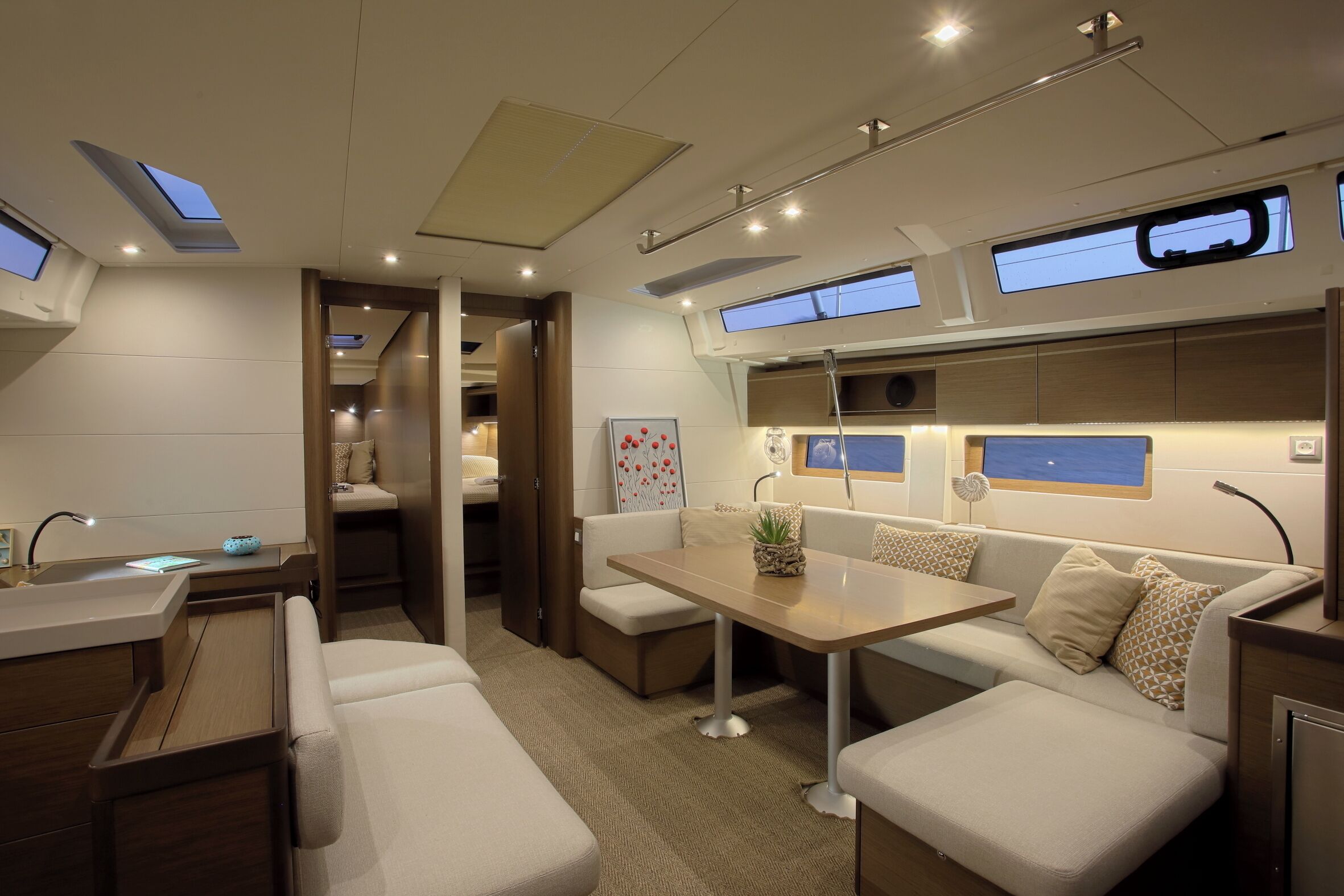 A modern interior with a sofa, table, and a small kitchen area.