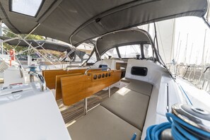 Das Innere eines Bootes mit einer Sitzecke, einer Steuerung und Blick auf den Hafen.