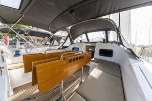 A boat's deck with a wooden seating area, metal railings, and a canopy overhead. - Sun-Kissed Sailing Adventure in Zadar, Croatia (Zadar)