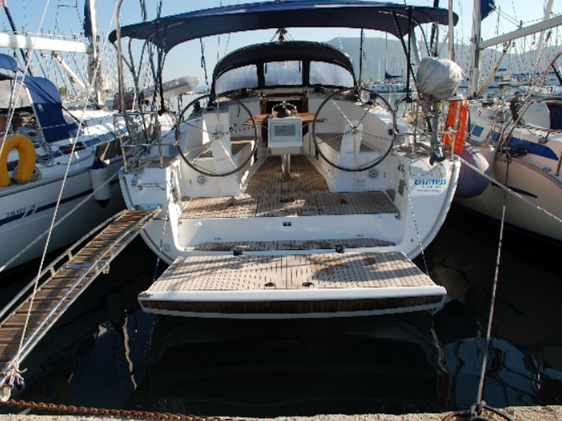 A boat with a covered deck, a steering wheel, and a small table.