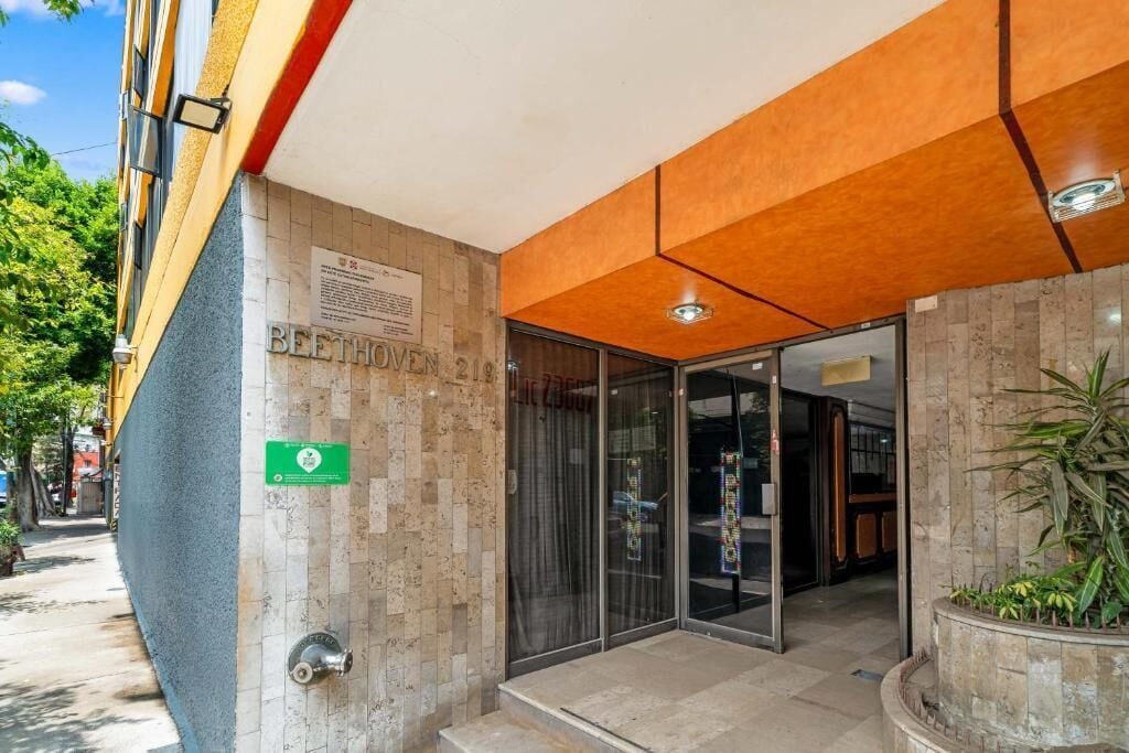 A building entrance with a sign reading 'BEETHOVEN 219' and a green sign with text.